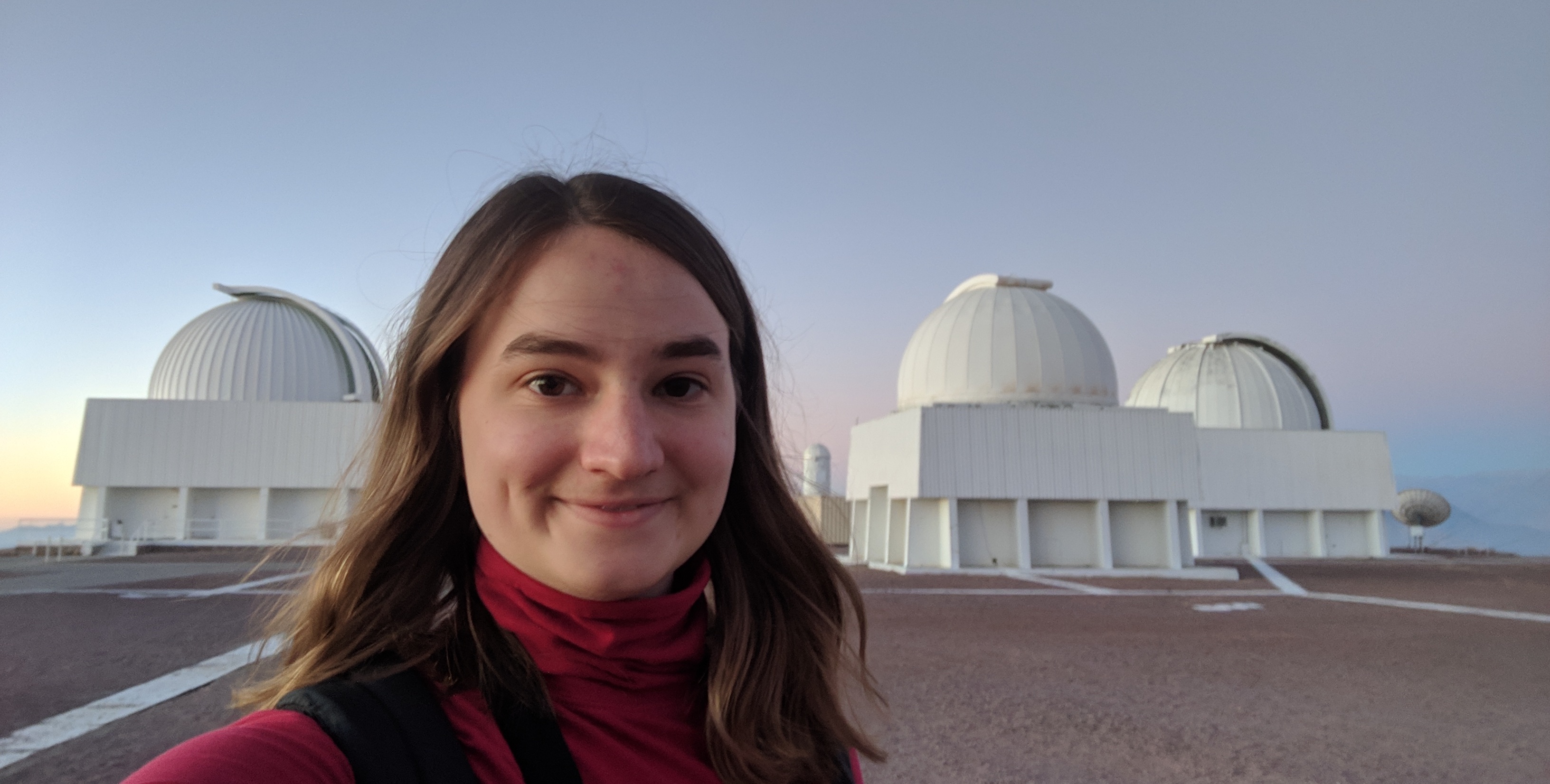 Rae at in front of several telescope domes